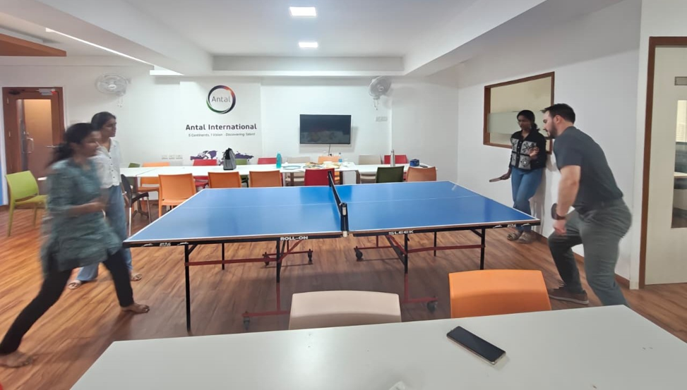 Team members playing table tennis in the shared office space